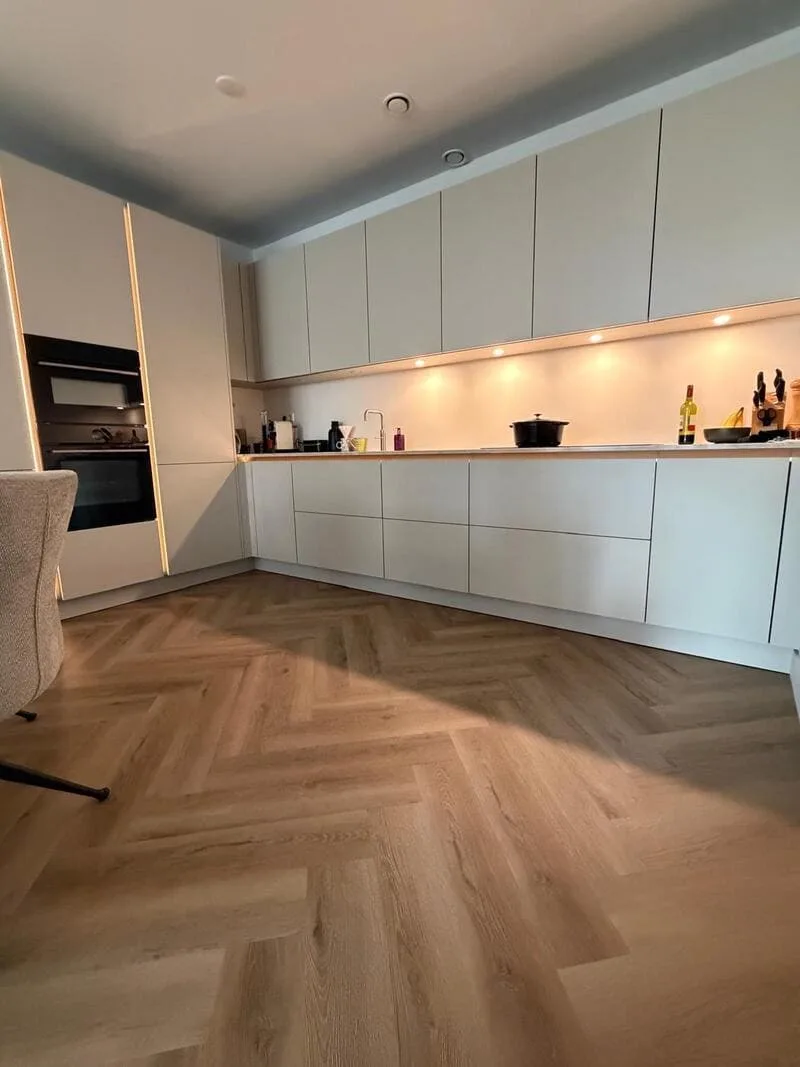 PVC visgraat vloer doorgelegd tot in de keuken van een appartement in Amstelveen